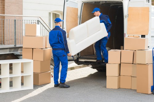 Professional piano movers using specialist equipment for transport